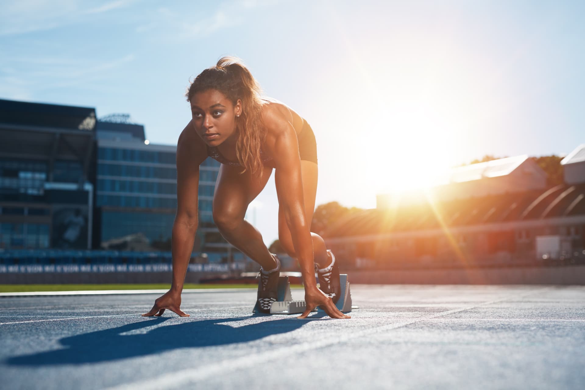 Collegiate athlete sprinting at golden hour